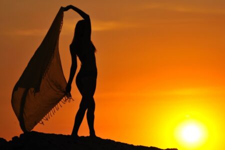 Silhouette of Woman Standing and Holding Pareo